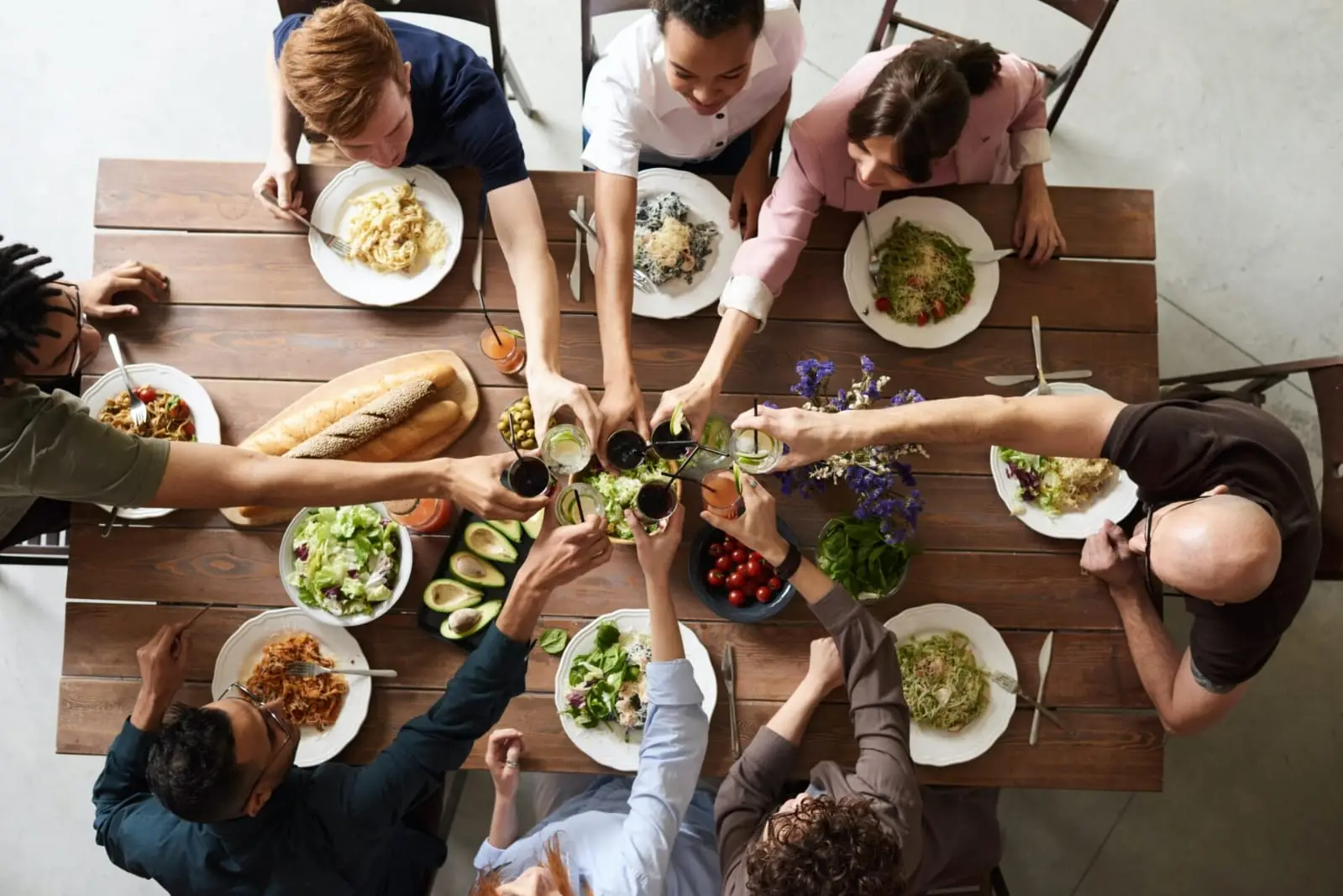 Amigos brindando alrededor de una mesa llena de comida